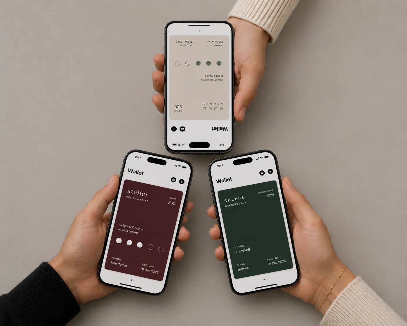 Trois personnes tiennent chacune leur iPhone, affichant dans Apple Wallet la carte de fidélité d’un commerce différent : un café-boulangerie, un studio et un club
